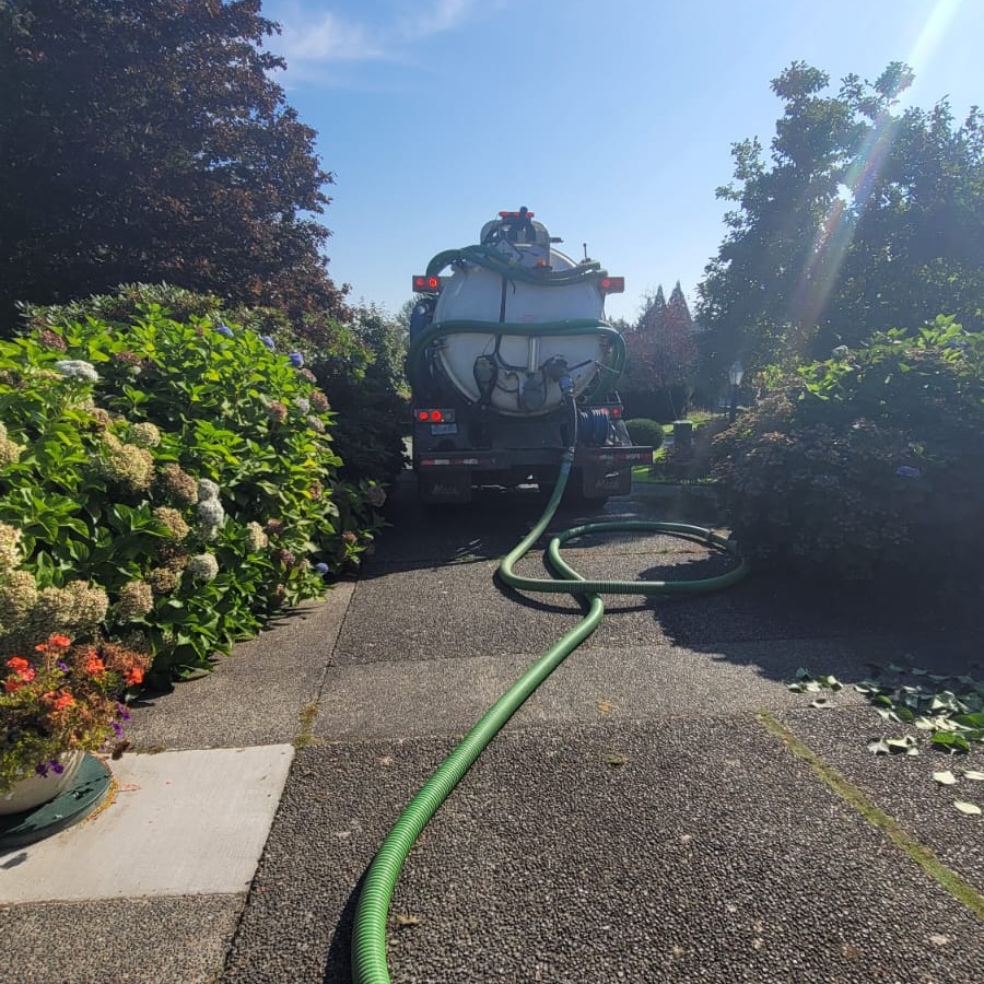 Clearset VAC truck running a line to a septic holding tank
