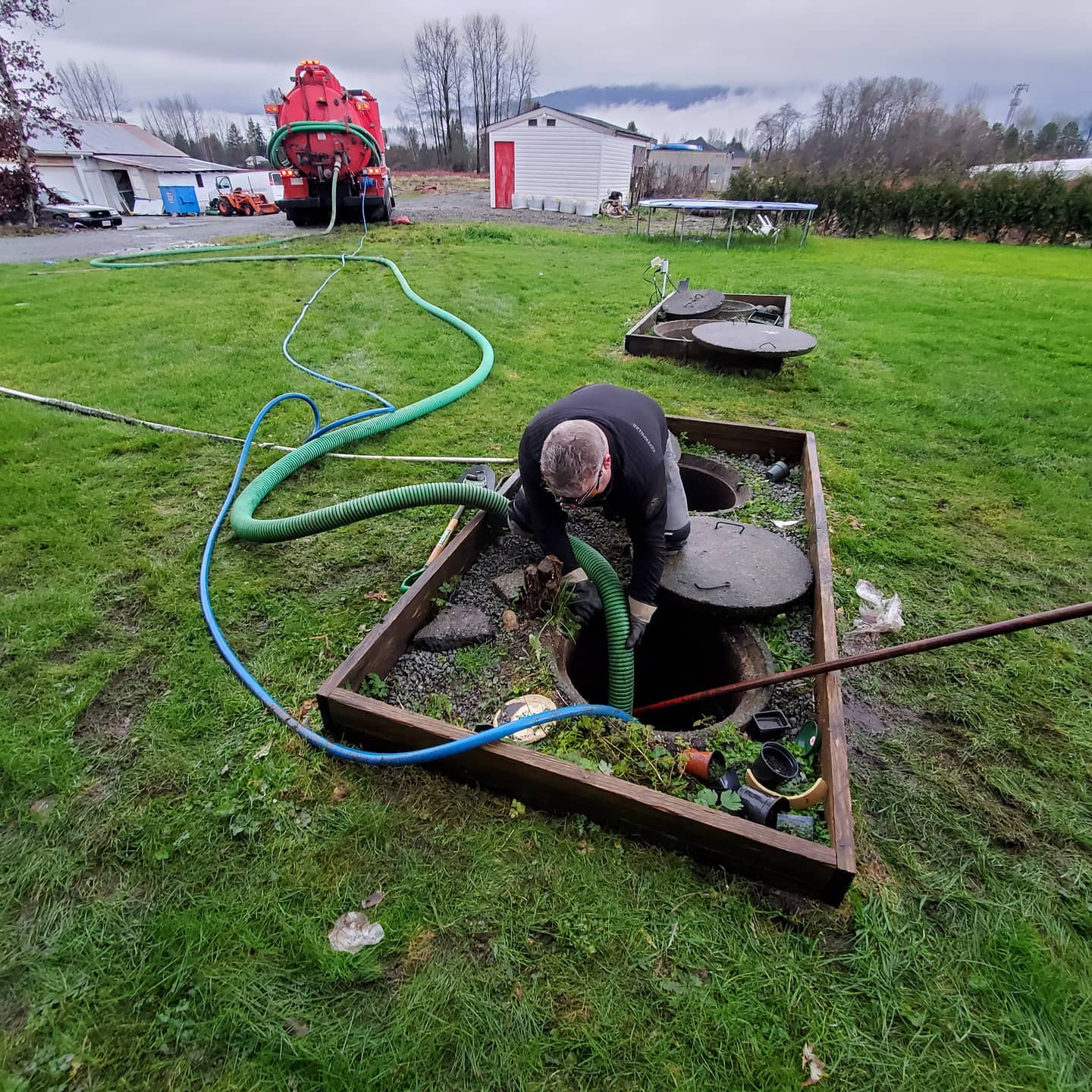septic tank pumping service being performed by a man running a hose from Clearset's vacuum truck