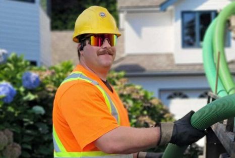 Smiling septic tech performing a holding tank cleaning from Clearset VAC Truck in BC's Lower Mainland