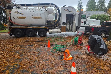 Clearset employee popping out of a storm drain, smiling, while performing a hydrojetting service in the BC Lower Mainland