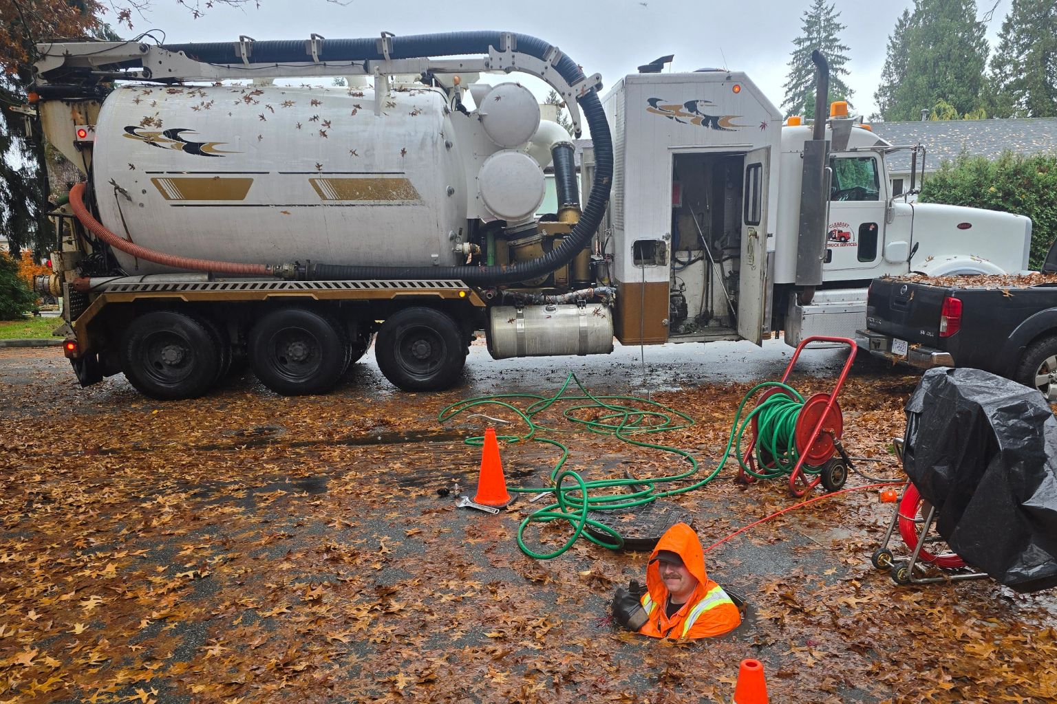 Clearset employee popping out of a storm drain, smiling, while performing a hydrojetting service in the BC Lower Mainland